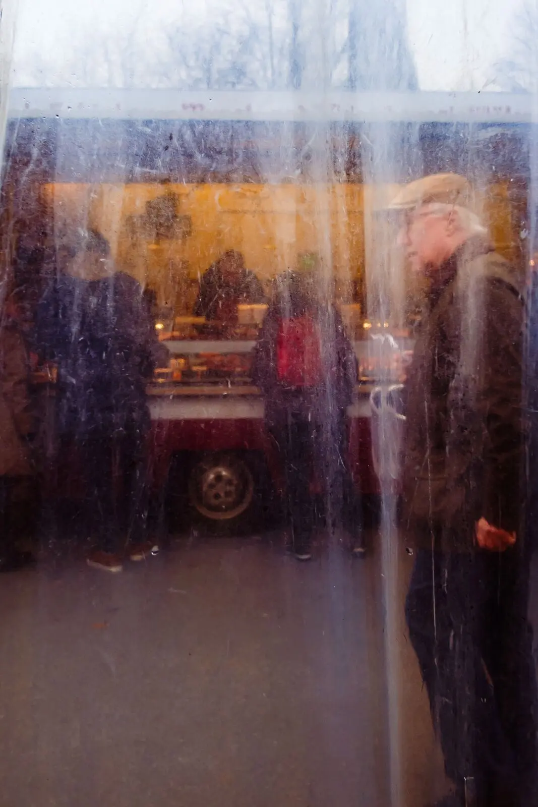 A market food stall seen through a fogged tarpaulin